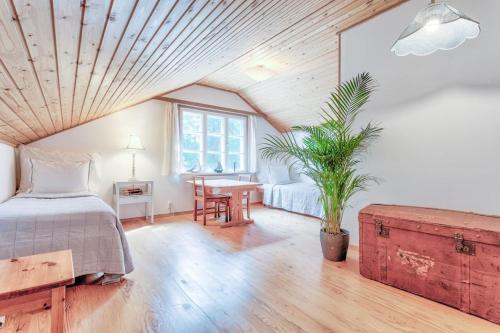 基尔科努米Villa Porkkala - Seafront Jacuzzi Nature Reserve的一间卧室配有一张床和一张植物桌子