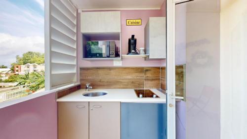 拉特里尼泰150 de Grey Studio pour 2 avec SPA, Vue sur mer的一个带水槽和窗户的小厨房
