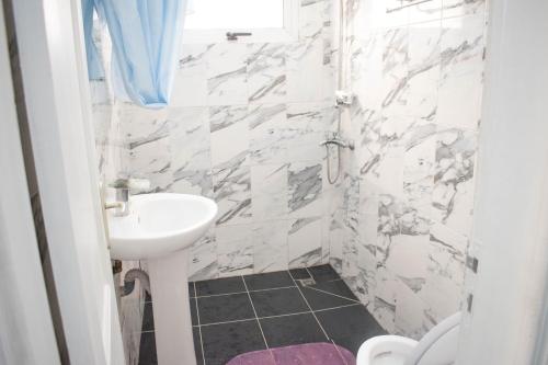 黑角Studio moderne avec Balcon的白色的浴室设有水槽和卫生间。