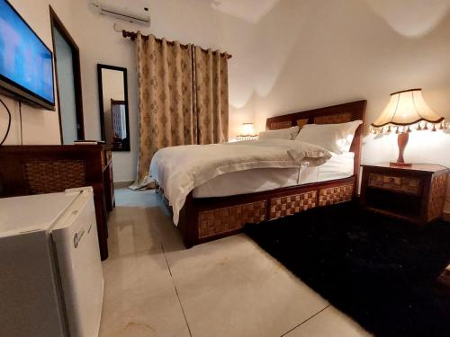 BenguelaHotel Residencial Ramire-Tour的一间卧室配有一张床和一台电视