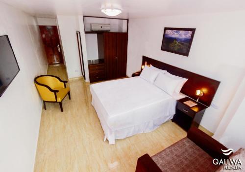 普卡尔帕Qallwa Pucallpa的卧室配有白色的床和黄色椅子