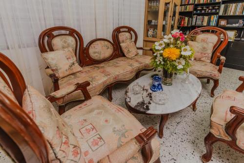 蒙特里亚Casa Hotel Miriam的客厅配有椅子和一张带花瓶的桌子
