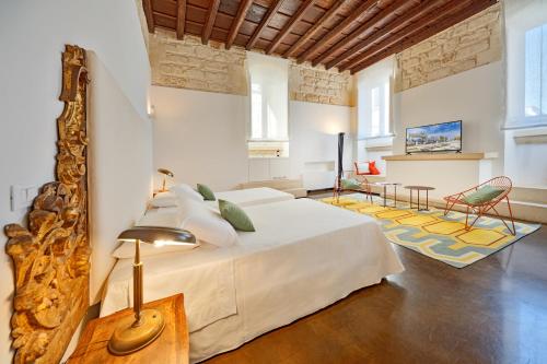 莱切Palazzo Personè Dimora Storica的一间带大床的卧室和一间客厅