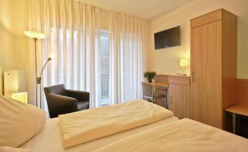 蒙绍卡尼哈勒酒店的配有一张床、一张书桌和一扇窗户的酒店客房