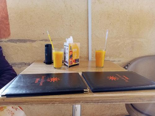 Sunciti Resort Sagana的一张桌子,上面放有两台笔记本电脑和两杯橙汁