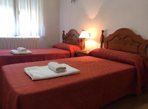 绍塞列Hospedería municipal la cultural的酒店客房,配有两张带红色床单的床