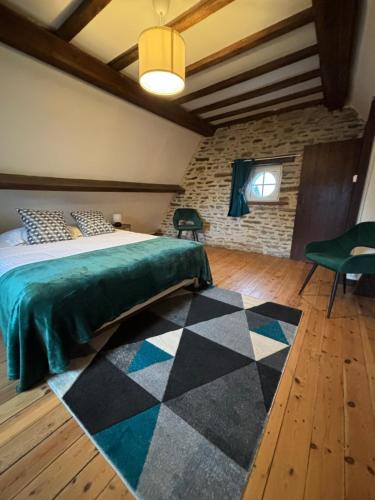蓬托尔松Gîte de la petite tour的一间卧室配有一张床,铺有一个 ⁇ 板地板