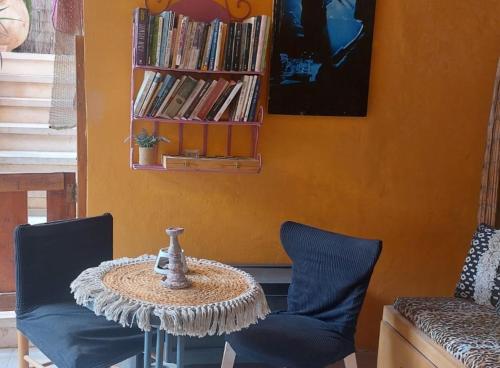 埃拉特Hanna's Place - Great Location的一张桌子、两把椅子和书架