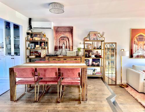 蒙特利尔Beautiful Luxury Shared Home in Montreal的厨房配有木桌和粉红色的椅子