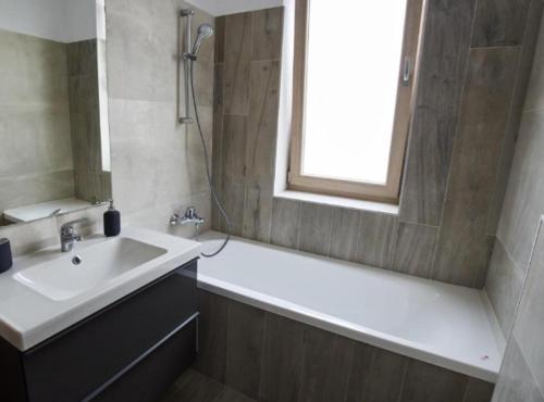 巴克乌Lux Apartament Bacău的一间带水槽和浴缸的浴室以及窗户。