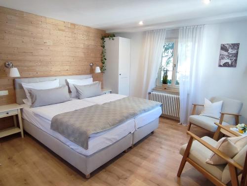 登茨林根Boutique-Hotel Krone的卧室配有一张白色大床和一把椅子