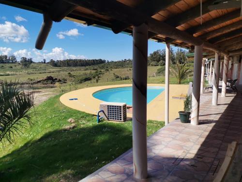Pan de AzúcarLa casa del Lago的从房子的门廊上可欣赏到游泳池的景色