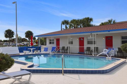 圣徒皮特海滩Sun Island Motel的一座带椅子的游泳池以及一座建筑