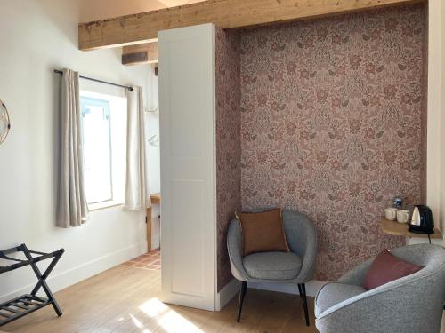 阿姆博斯Maison Chemin, chambres d'hôtes à Amboise的客厅配有两把椅子和窗户