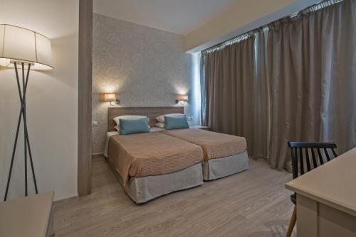 罗希姆诺Lefkoniko Beach & Icarus Suite Apts的一间卧室配有一张带两个蓝色枕头的床