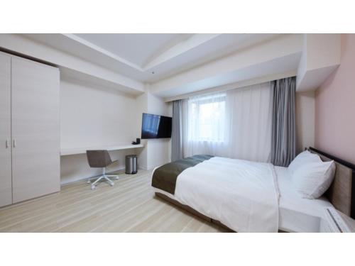 厚木Rembrandt Hotel Atsugi - Vacation STAY 41674v的配有一张床和一张书桌的酒店客房