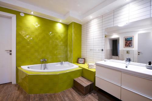 卡瓦拉Our Happy Place Maisonette的绿色浴室设有两个盥洗盆和一个浴缸