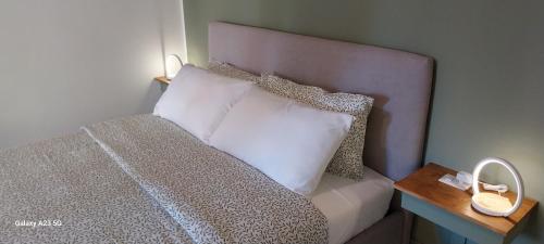 佩罗Little Sweet Home - Fiera Milano的一张带白色枕头的床和木制床头柜