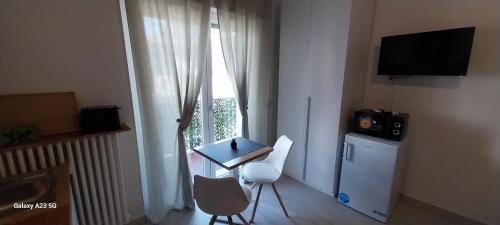 佩罗Little Sweet Home - Fiera Milano的一间设有桌子、电视和窗户的房间