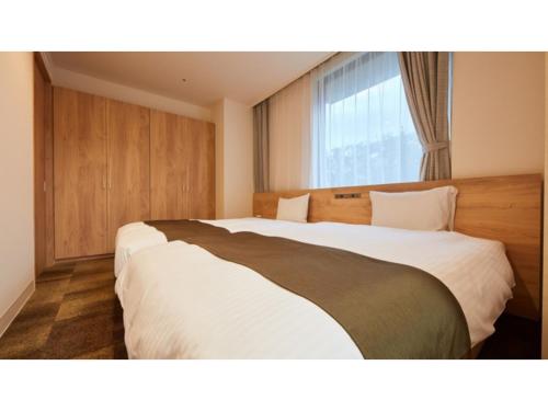 厚木Rembrandt Hotel Atsugi - Vacation STAY 41678v的酒店客房设有两张床和窗户。