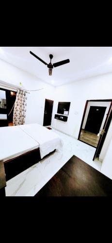 印多尔Paradise Inn的卧室配有白色的床和吊扇