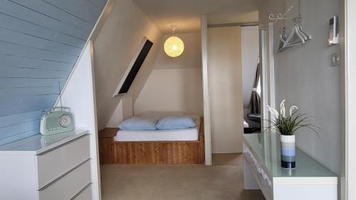 斯塔福伦Slapen aan het IJsselmeer的小房间设有床和楼梯