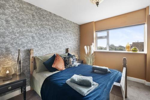 KentThe Beacon, apartment next to the seafront in Herne Bay的一间卧室设有蓝色的床和窗户。