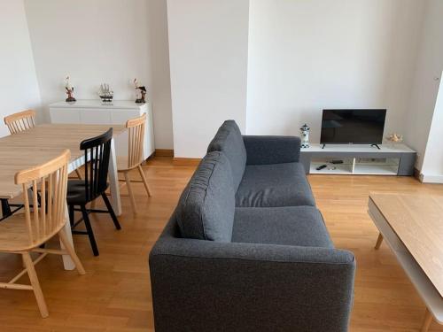 敦刻尔克l'Éclat du Littoral Vue mer - Good Home的客厅配有蓝色的沙发和桌子