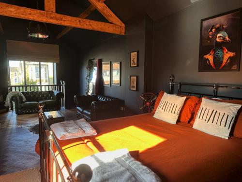 莫克姆The Balmoral Coach House的一间卧室配有一张带橙色床罩的床