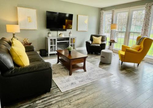 皮克顿Mileva Retreats的客厅配有沙发、椅子和电视
