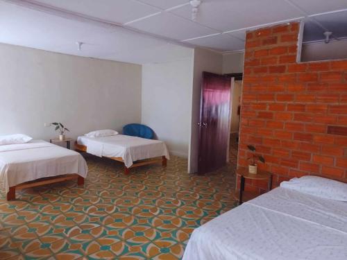 塔拉波托hotel Suyay Lodge Tarapoto的酒店客房带两张床和砖墙