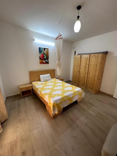 圣路易斯Chambre spacieuse avec balcon - salle de bain extérieure privée & breakfast的铺有木地板的客房内设有一间卧室和一张床。