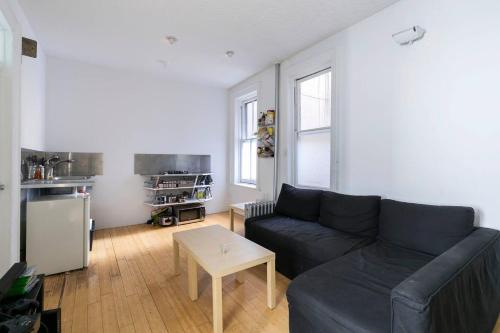 纽约Sundrenched East Village Apartment的客厅配有沙发和桌子