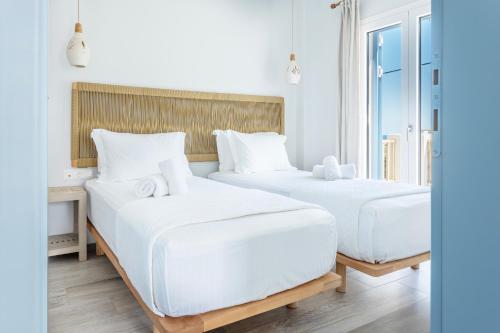 阿齐亚·佩拉加·基西拉Alsea Seafront Apartments in Agia Pelagia Kythera的配有白色床单的酒店客房内的两张床