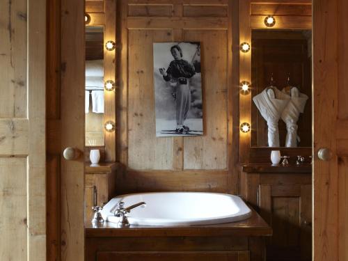 梅杰夫Hotel Mont Blanc Megève的带浴缸的浴室和墙上的照片