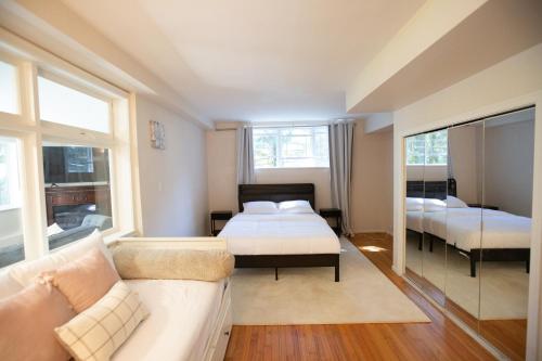 西温哥华Private Garden-Level Suite的一间带两张床和一张沙发的卧室