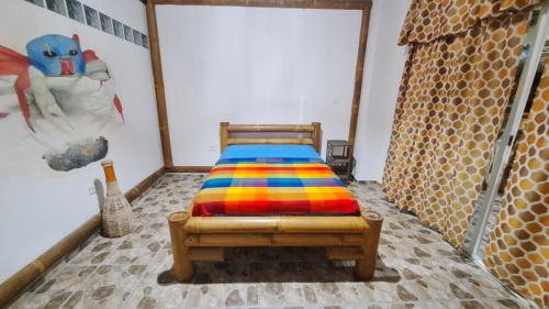 莫姆皮切Casa Gaia: Un Paraiso的一间卧室配有一张带彩色毯子的床