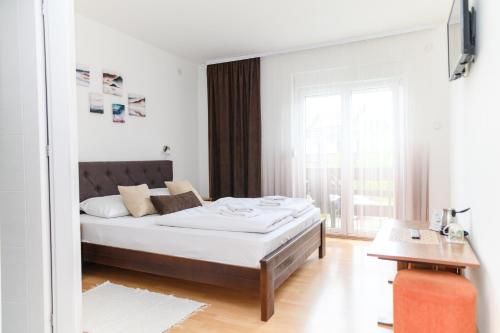 索科矿泉村Apartmani Zvirac的白色的卧室设有床和窗户