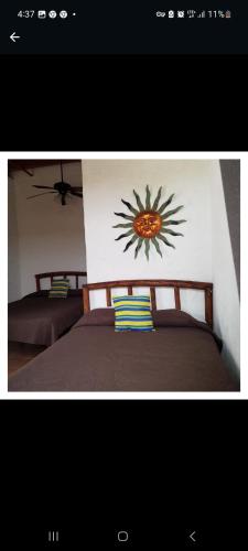 San CarlosSancarlosbeach的一间卧室设有两张床,墙上挂着一幅阳光画