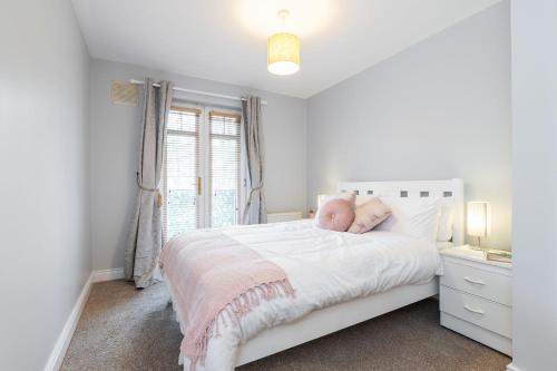 索兹Holywell Rise Swords的白色的卧室设有白色的床和窗户。