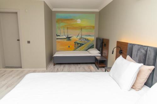 SazlıKayalar Blue Beach Hotel的卧室配有一张床,墙上挂有绘画作品
