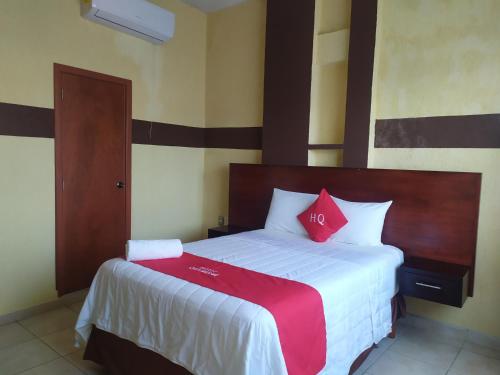 夸察夸尔科斯Hotel Quetzalcóatl的一间卧室配有一张带红色枕头的大床