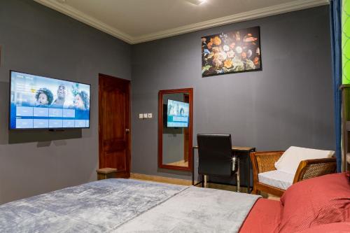 阿克拉BlueGreen GuestHouse的一间卧室配有一张床和一台平面电视