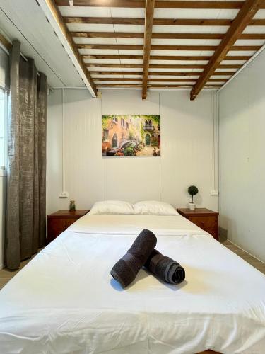 海法Ramban Emerald的卧室配有白色的床和可移动的毛巾