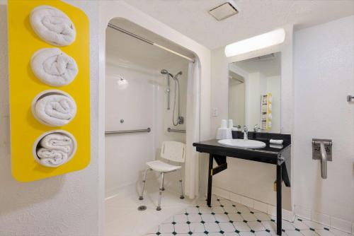 博蒙特Motel 6-Beaumont, TX的墙上设有带水槽和毛巾的浴室