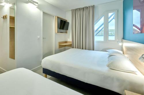 YzeureKyriad Direct Moulins Sud - Yzeure的酒店客房设有两张床和窗户。