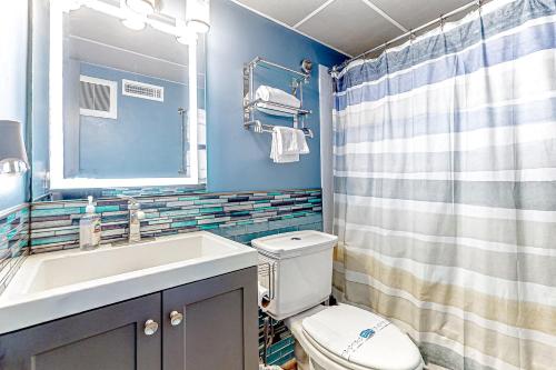 大洋城Assateague House 205的一间带卫生间、水槽和镜子的浴室