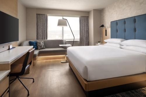 圣何塞圣何塞万豪酒店的酒店客房设有一张大床和一张书桌。
