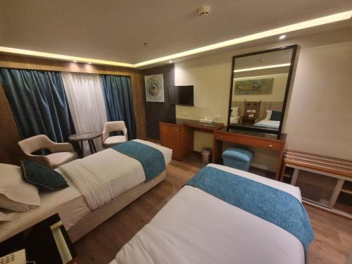 Aḑ Ḑab‘īyahNile Cruise Start From Luxor & Aswoan included Sightseeing的酒店客房,设有两张床和镜子