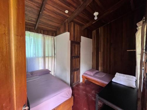 GandocaShiosai Retreat Cabins的小房间设有两张床和窗户